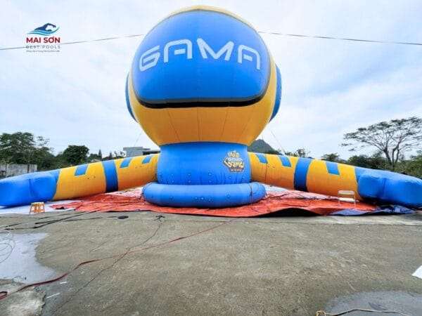 Linh vật bơm hơi GAMA đang được dựng trên sân bê tông ngoài trời